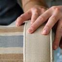 Close-up of hands upholstering premium fabric on furniture